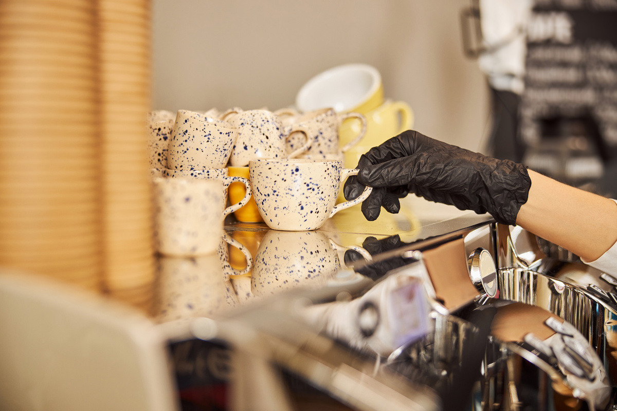 Gloved hand preparing coffee